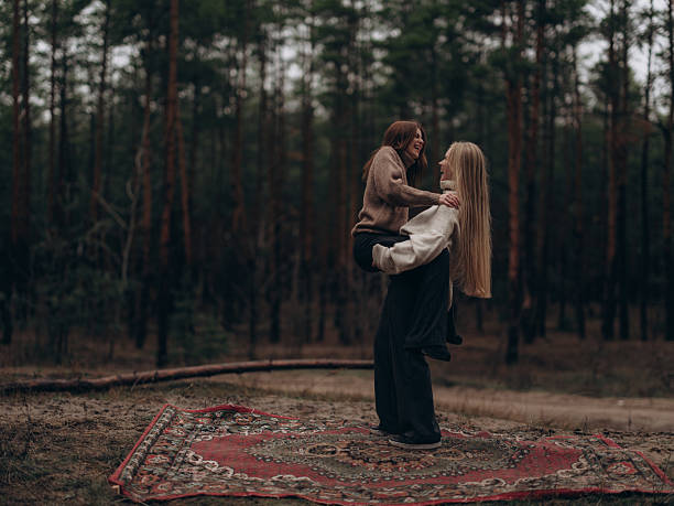 istock Joyful lesbian couple having fun and laughing passionately on carpet in forest 2247782593