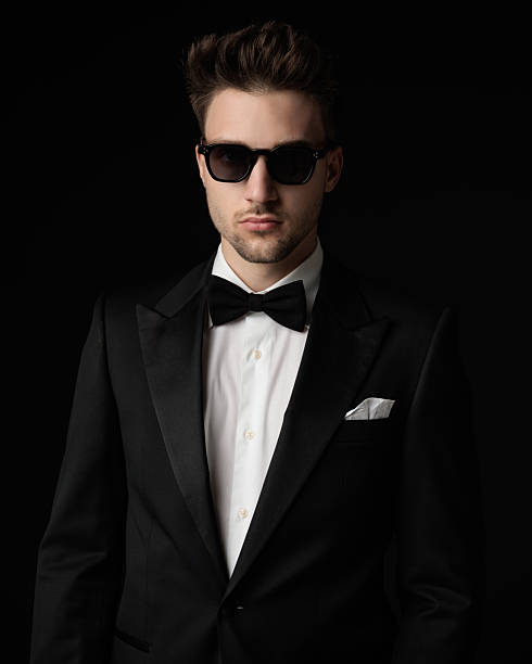 istock sexy young man in black tuxedo with sunglasses looking forward 2247783362