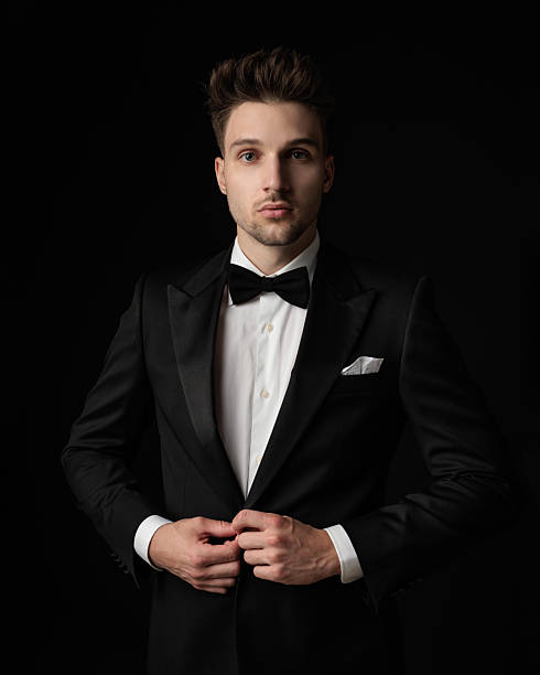 istock attractive man with blue eyes looking forward and closing black tuxedo 2247783409