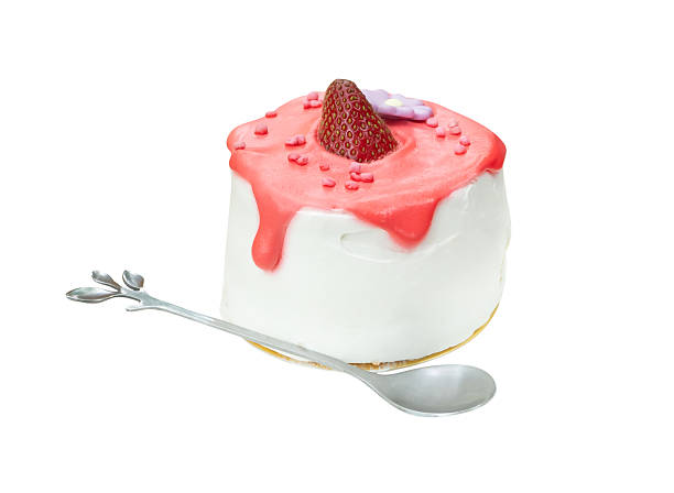 Strawberry cake with glazed cream and mini silver spoon or tea spoon is isolated on white background with clipping path.