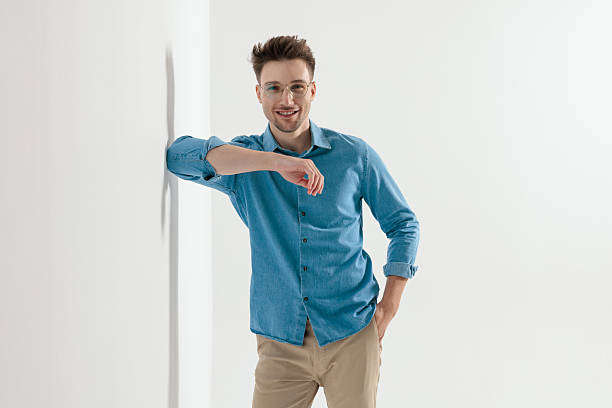 istock Happy young casual man smiling and leaning elbow on wall 2247784193