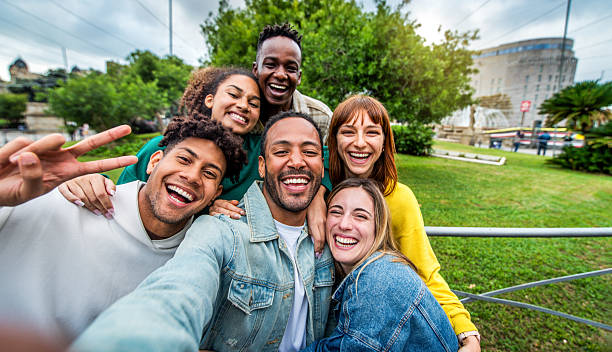 istock Multicultural cheerful friends taking selfie pic with smart mobile phone device - Youth community people laughing at camera together - Friendship concept with guys and girls having fun outdoors 2247785556