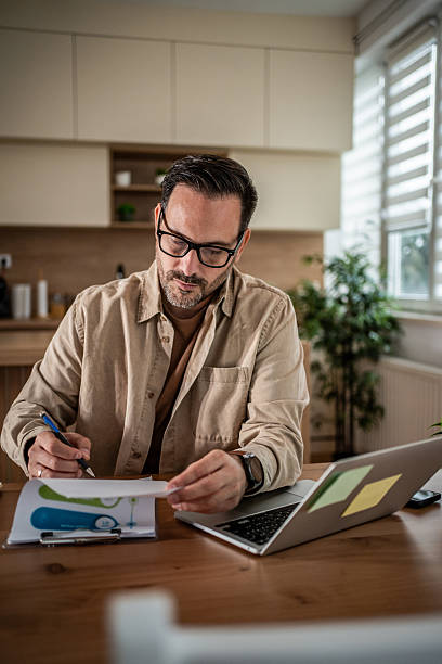 istock Man working from home office reviewing business documents 2247787947
