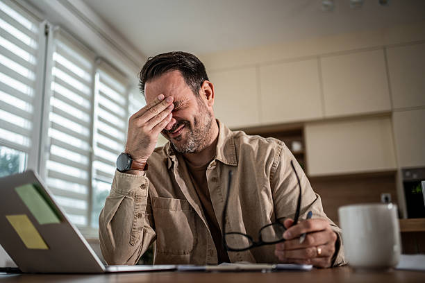 istock Stressed man suffering from headache and eye strain at home 2247787994