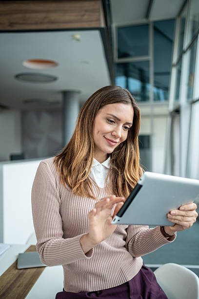 istock Businesswoman smiling using digital tablet in office 2247788430