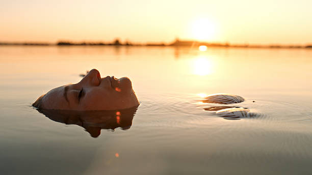 istock Relaxed Caucasian Woman Enjoys Evening Lake Drift at Sunset 2247789052