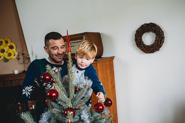 istock Father and son decorating christmas tree at home 2247789208