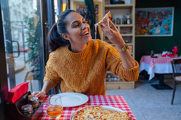 Beautiful young woman having a pizza in the restaurant