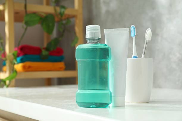 istock Bottle of mouthwash, toothbrushes and toothpaste on white table in bathroom. Space for text 2247793818