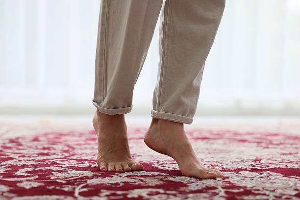 istock Woman walking barefoot on red carpet with pattern at home, closeup 2247794165
