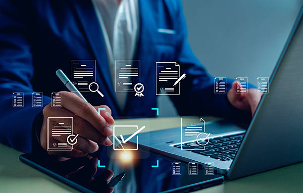 istock business professional using a laptop and tablet for digital document approval and e-signature. Concept of online verification, paperless workflow, business automation, and data compliance. 2247798459