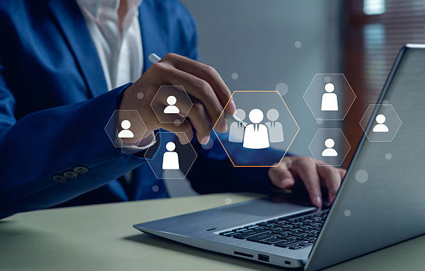 istock business professional using a laptop and stylus to select a virtual team icon. Concept of digital human resource management, recruitment, leadership, teamwork, and business networking. 2247798484