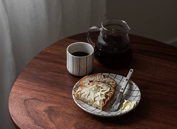 istock Breakfast table - black coffee, sourdough bread with butter on a wooden table 2247799011
