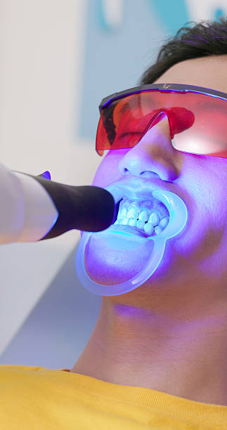 istock elderly dentist proceed led teeth whitening treatment 2247799119