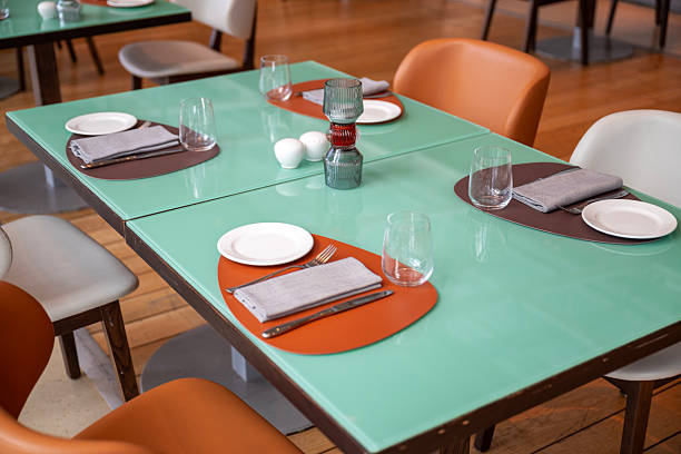 Restaurant table setup with orange tablecloth and utensils