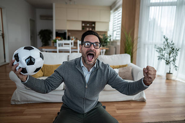 istock Excited man watching soccer match at home 2247800983