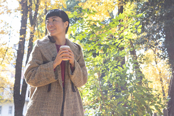 istock Woman enjoying coffee in autumn park 2247801335