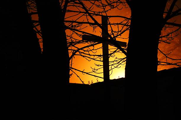 istock Cross Silhouette Against a Fiery Sky at night 2247803596