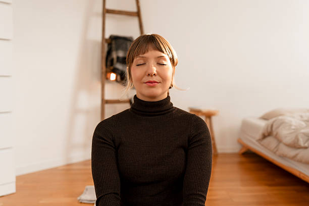 istock Woman in a black turtleneck meditating at home, practicing self-care, mindfulness, and inner calm 2247804836