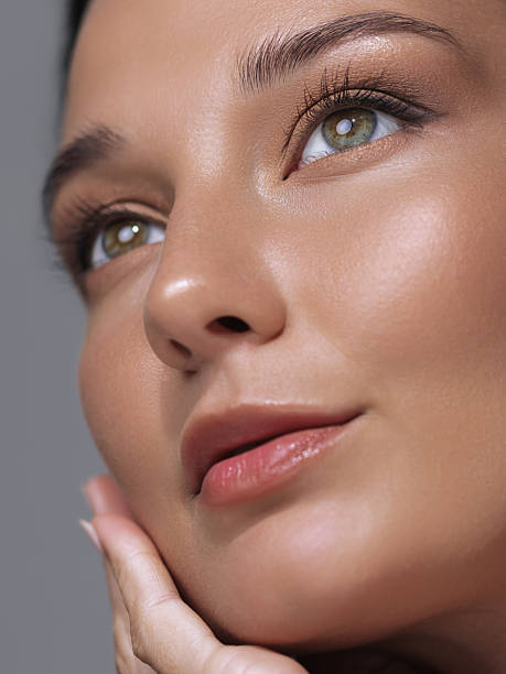 istock Woman with Glossy Lips and Radiant Skin Gently Touching Her Face 2247805871