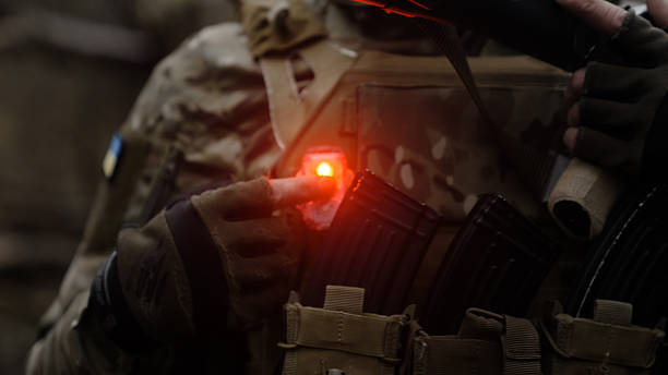 istock Soldier points at red light of IFF enemy indicator marker on camouflage 2247805991
