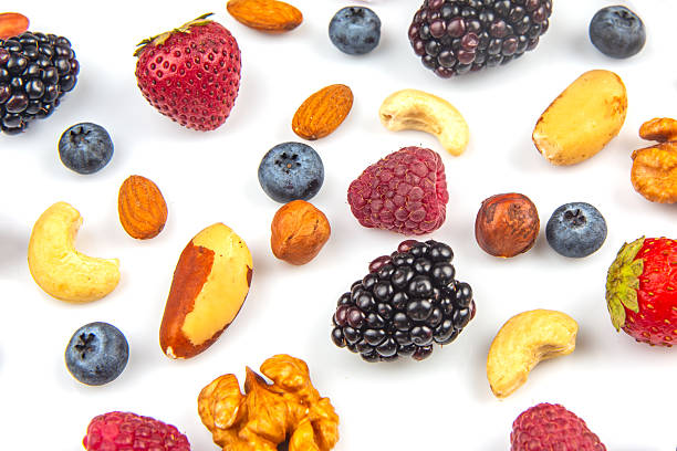 istock Colorful assortment of fresh berries and nuts arranged on a white background 2247806702