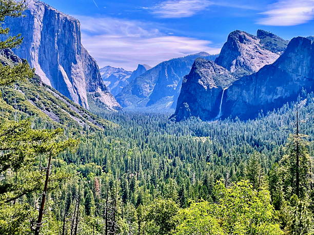 A sweeping vista of the Yosemite Valley to include Bridalveil Fall and Half Dome Peak as seen from the Tunnel View entrance at Yosemite National Park.