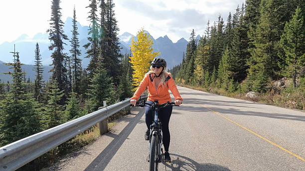istock Woman riding electric bicycle on mountain road 2247807123