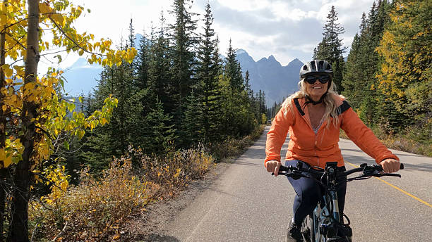 istock Woman riding electric bicycle on mountain road 2247807136