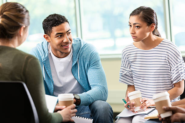 istock Diverse group of young adults engaging in thoughtful discussion during a meeting or therapy session. 2247807141