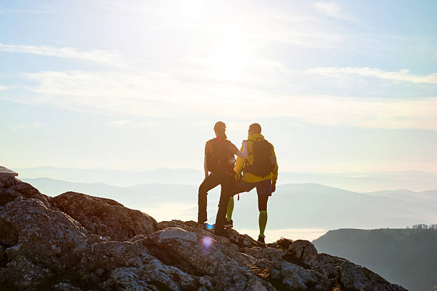 istock Couple enjoying breathtaking view from mountain peak during sunset on a clear day 2247807435