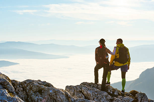 istock Couple enjoying breathtaking view from mountain peak during sunset on a clear day 2247807655