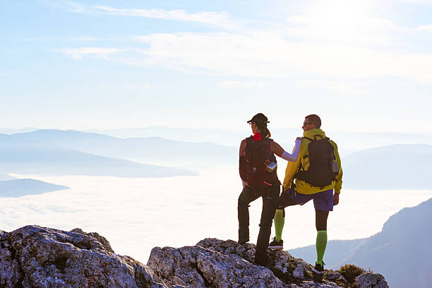 istock Couple enjoying breathtaking view from mountain peak during sunset on a clear day 2247809660