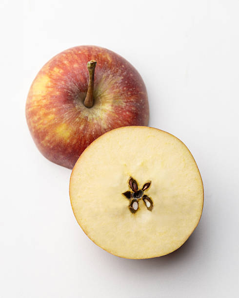 istock Fresh red apple sliced in half on white background 2247811099
