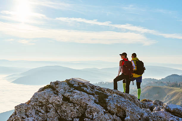 istock Couple enjoying breathtaking view from mountain peak during sunset on a clear day 2247811264