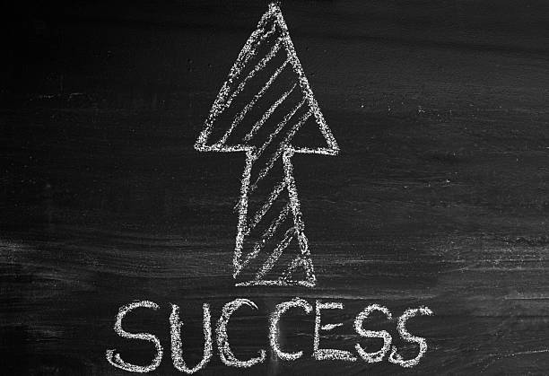 Success Written White Arrow On chalkboard