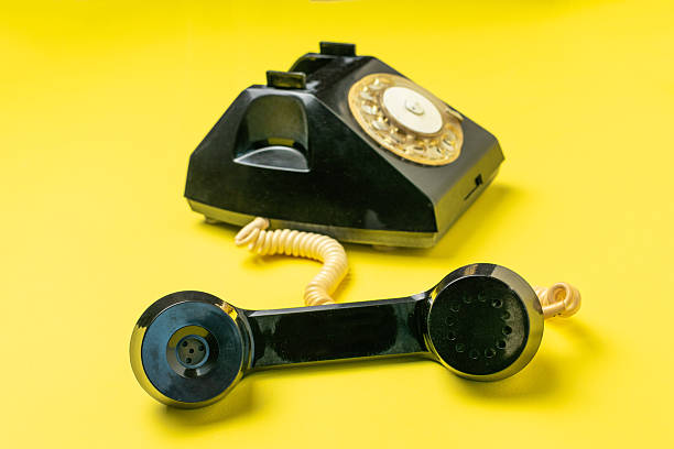 istock Vintage Rotary Phone with Off-The-Hook Receiver on Bold Yellow Background 2247814716