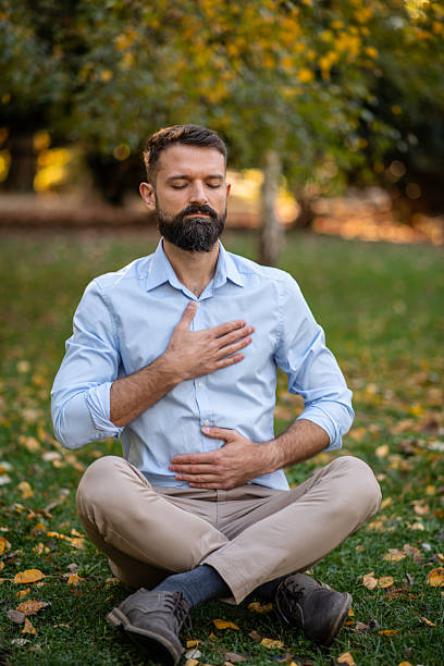 istock Businessman doing breathing exercises in park 2247816520