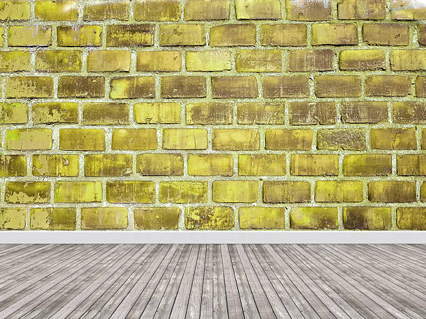 istock Old yellow brick wall in empty room with floor 2247820357