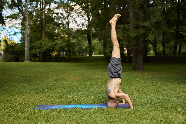 istock A man practicing yoga in the park, performing an inversion pose with grace and focus 2247822039