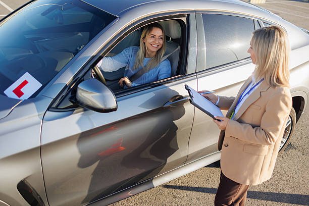 istock Driving Student Talking with Instructor beside Car during License Exam 2247822959