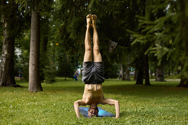 istock A man practices yoga in a park, skillfully demonstrating a challenging handstand pose 2247822989