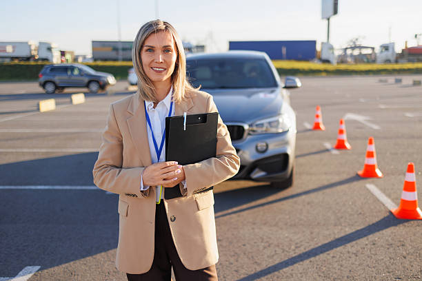 istock Instructor Standing by Learner Car with L Plate and Traffic Cones 2247823383