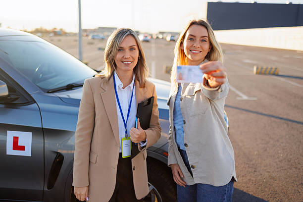 istock Driving Instructor Approving Student's New License with Thumbs Up Gesture 2247823789