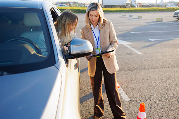 istock Driving Teacher Reviewing Paperwork with Student Inside Training Car 2247824145