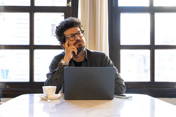 istock Thoughtful businessman working remotely from cozy cafe 2247827789