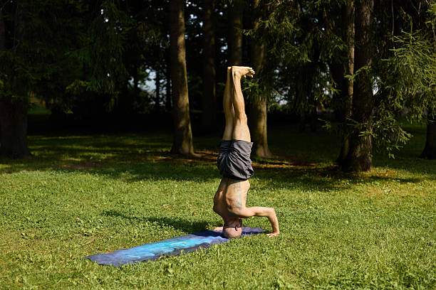 istock A man is practicing yoga outdoors in a headstand pose surrounded by nature and greenery 2247827957