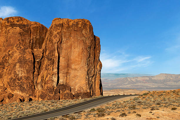 As daylight fades over Valley of Fire State Park, the park's red sandstone formations glow beneath a blue evening sky. The waning sunlight highlights the desert landscape, balancing warm stone against a cooling sky. The scene captured the quiet transition between day and night in one of Nevada's most striking desert environments.