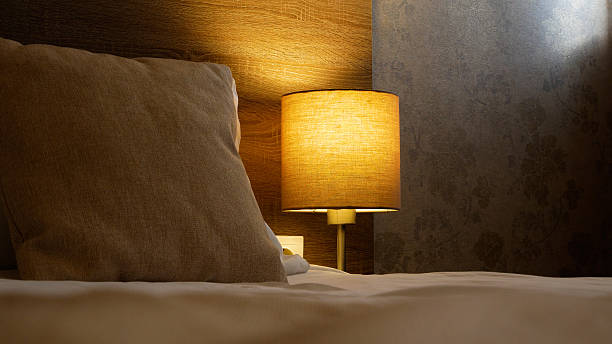 istock Bedroom interior. A bed with a pillow, next to it is a lamp on. 2247831305