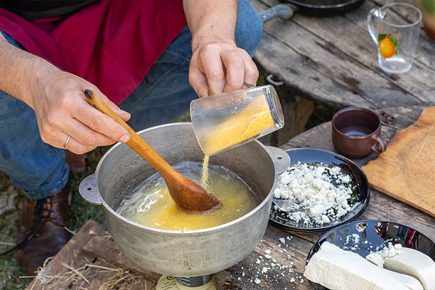 istock Man Preparing Rustic Polenta with Sheep Cheese on Open Fire. Authentic Countryside Cooking. Rustic Outdoor Meal. 2247832652